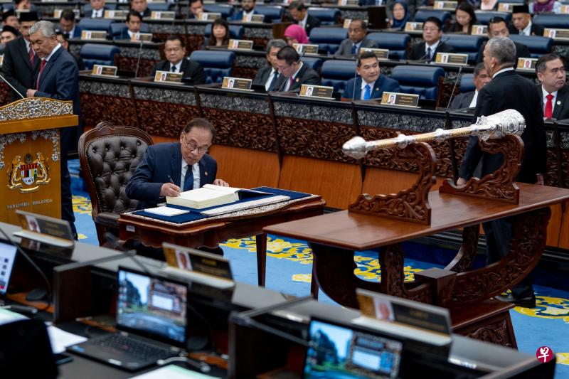 马来西亚新国会星期一召开第一次会议，首相安华宣誓就任议员后签下就职文件。（马国首相办公室提供）
