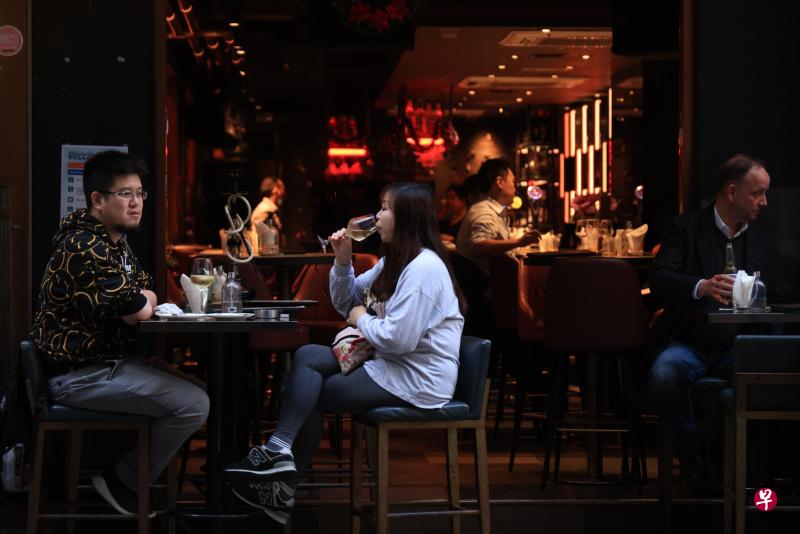 香港特区政府12月20日公布最新防疫安排，包括撤销酒吧、夜店、参与宴会人士、参加当地游旅客的快速抗原测试要求。图为香港市民于酒吧休闲。（香港中通社）