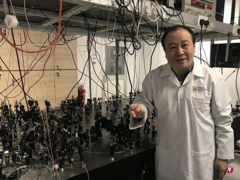 小小米粒般的晶片，对比刘爱群教授身边满满一桌的玻璃镜子，量子晶片不仅节省空间，信息传送速度更是惊人。普通计算机以年数完成的计算工作，使用量子晶片的计算机顷刻就完成了。（苏秉苓摄）