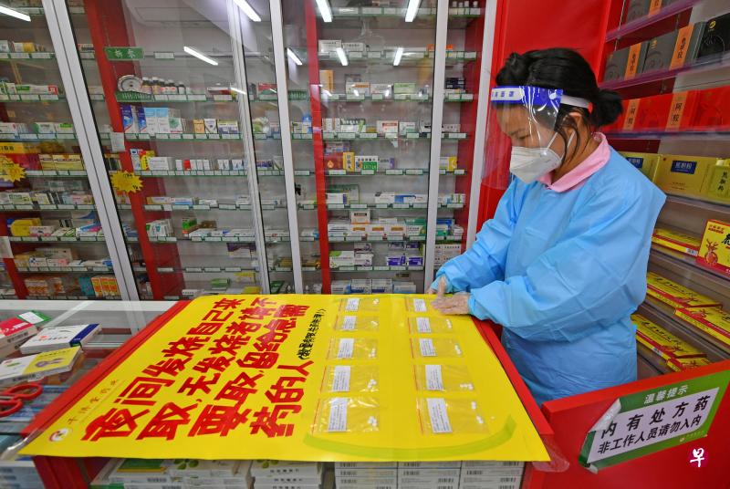福建泉州正值冠病疫情暴发之际，当地一家药店免费分发布洛芬（ibuprofen）消炎药给发烧病人，职员把布洛芬进行分装。（路透社）