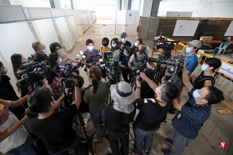 疫情期间，新报业媒体信托的记者和摄影同事和其他同行一个个戴着口罩，深入“高危地点”采访最新消息。图为时任人力部长杨莉明2020年走访一个拭子测试隔离设施并接受媒体采访。（档案照片）