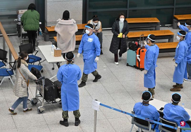 韩国目前规定来自中国的航班只能在仁川国际机场降落。图为仁川国际机场可见许多卫生官员及穿防护衣的军人协助中国旅客到冠病检测中心接受检测。（法新社）