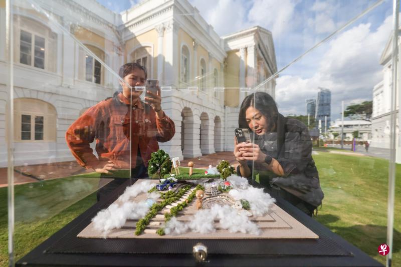 公众在布景设计师黄雪宣为“独特城市”展区创作的作品前，拍摄这一独具匠心的创作。这个展品由木材、黏土和树脂制成，表达都市人对别样城市的向往。（卓祾祎摄）
