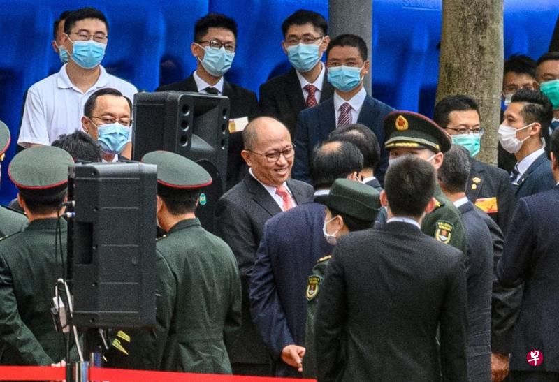 出生在广东汕头的郑雁雄（中，未戴口罩者）通晓粤语，也是首名有国安工作背景的香港中联办主任。图为2020年7月8日中央驻港国安公署举行开幕仪式，郑雁雄与到场嘉宾寒暄。（法新社）