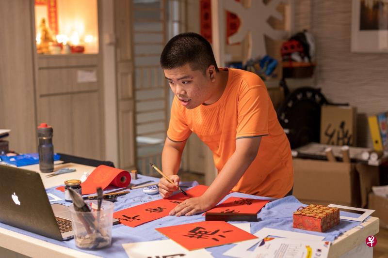 农历新年期间，李俊乐拿起毛笔写春联。（受访者提供）