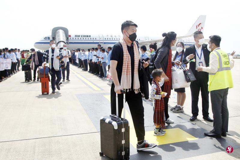 载有125名乘客的中国航班2月7日降落在柬埔寨首都金边国际机场，现场有柬埔寨传统舞蹈昌扬舞表演，柬埔寨旅游大臣童昆和中国驻柬埔寨大使王文天（不在图中）前往接机。（新华社）