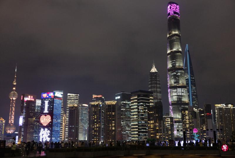 图为2月14日情人节的上海外滩，不少民众在外滩金融中心的商场露台，在高达6米的巨型玫瑰艺术装置（右下）前拍照留念。（新华社）