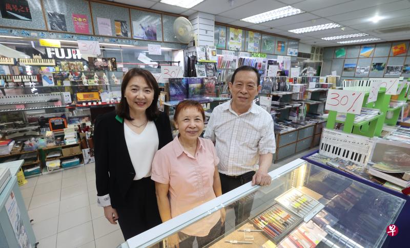 经营书城音乐书局43年，郭文发（右）和陈丽辉（中）夫妇决定结束营业，为个人、店面和业务翻开新篇章。同样在百胜楼的老字号友联书局将接手部分业务，负责人马晓敏承诺，会继续照顾书城的老顾客。（唐家鸿摄）
