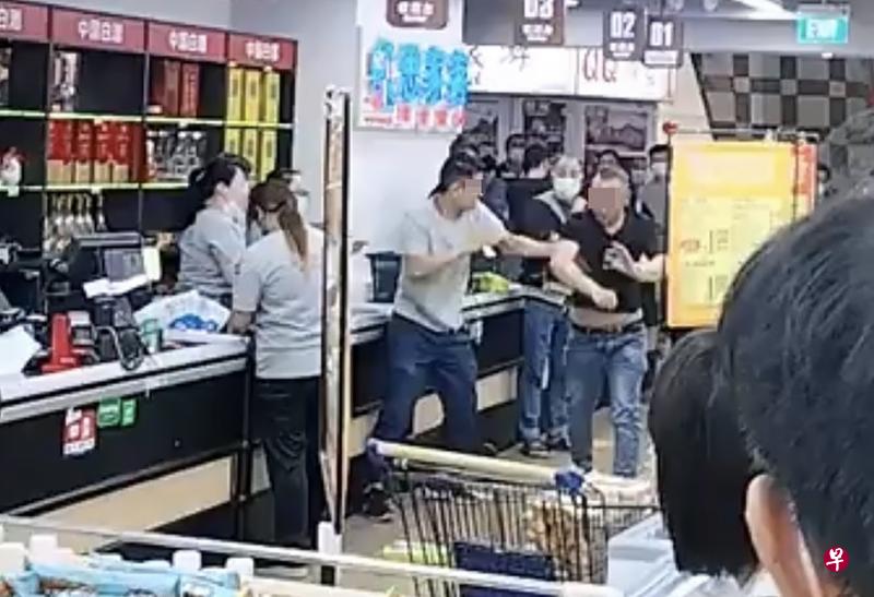 黑衣男闹事还动手，穿着灰衣的男店长出手阻止对方动粗。（视频截图）