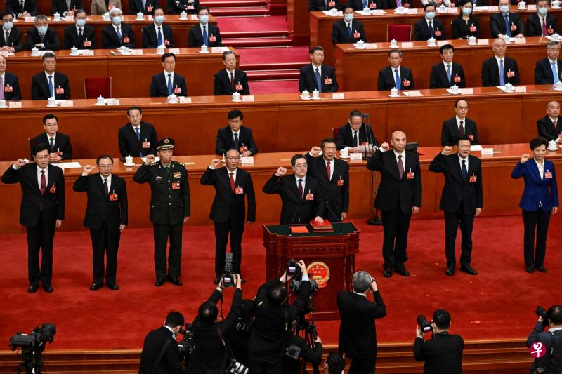 由排名第一的国务院副总理丁薛祥（前排中）星期天领誓，国务院副总理以及国务委员星期天（3月12日）集体进行宪法宣誓就职。 后排左起为秦刚、吴政隆、李尚福、张国清、何立峰、刘国中、王小洪和谌贻琴。（法新社）