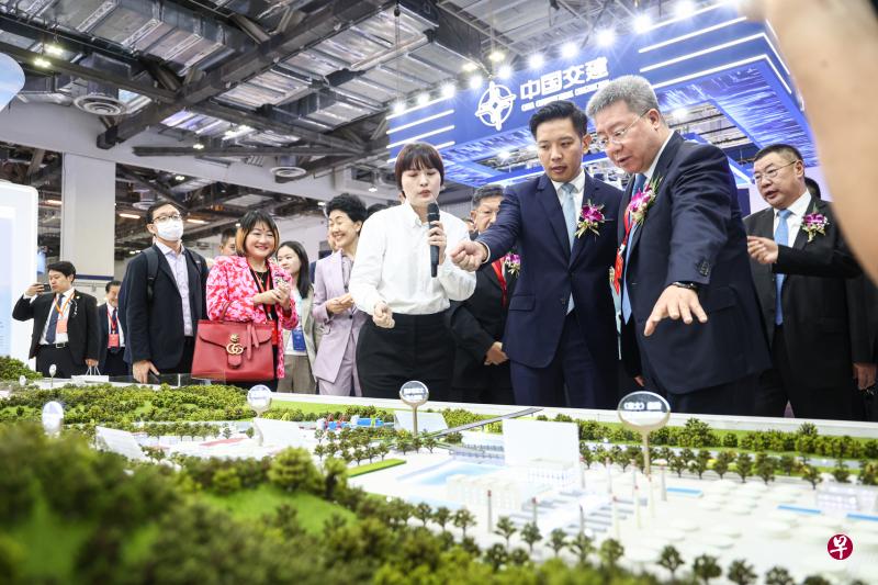 贸工部兼文化、社区及青年部政务部长陈圣辉（前排右二）走访中国机电产品品牌展览会，参展企业中国建筑集团有限公司董事长郑学选（前排右一）向他介绍会展内容。与陈圣辉一起参观的包括新加坡中华总商会会长高泉庆（陈圣辉背后，红色领带）、中国驻新加坡大使孙海燕（前排右四），以及中国机电产品进出口商会常务副会长郑超（后排右一）等。（李健玮摄）