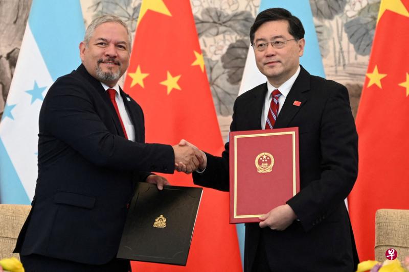 中国大陆外交部长秦刚（右）与洪都拉斯外长雷纳星期天在北京钓鱼台国宾馆，完成建交仪式后彼此祝贺。（路透社）
