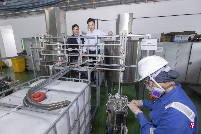 南洋理工大学与本地电池回收公司SWM合作建立试点回收厂，用果皮废料提取废旧电池中的贵重金属。图为南大材料科学与工程学院郑祖仰副教授（左）与SWM公司总经理吴耀坤（右）参观工厂运作。（陈来福摄）