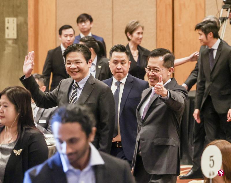 副总理兼财政部长黄循财（左）星期二出席行政服务晚宴及擢升仪式时挥手示意，与他一起入场的是公务员首长叶成昌（右）。（陈斌勤摄）
