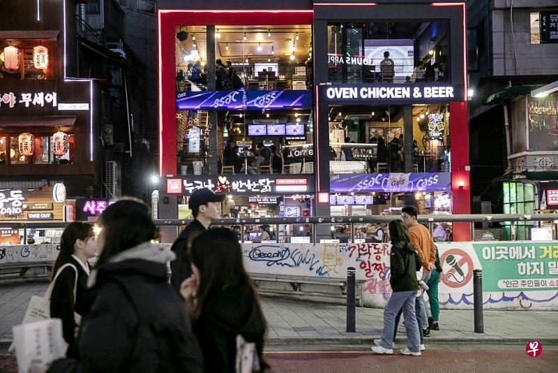 韩国总统尹锡悦指出，为应对众多外国游客来访，当局需要改善签证制度，也要尽快增加航班。图为首尔弘大商圈24日的景象。（彭博社）