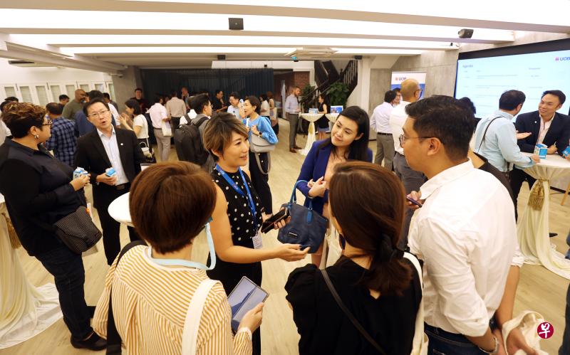 大华银行在3月底举行职业展准备招聘至少500人，并欢迎科技公司被裁员工加入。图为银行工作人员向求职者讲解待填补的职缺。（萧紫薇摄）