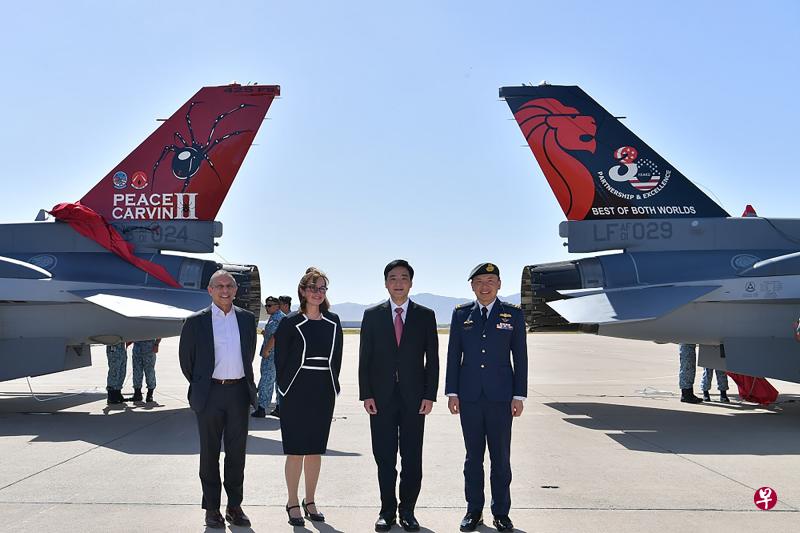 一架在美国卢克空军基地的F-16战机（右）尾翼印上象征图案，纪念“和平卡文”第二分遣队成立30年。国防部高级政务部长王志豪（右二）出席了图案揭幕仪式。（国防部提供）
