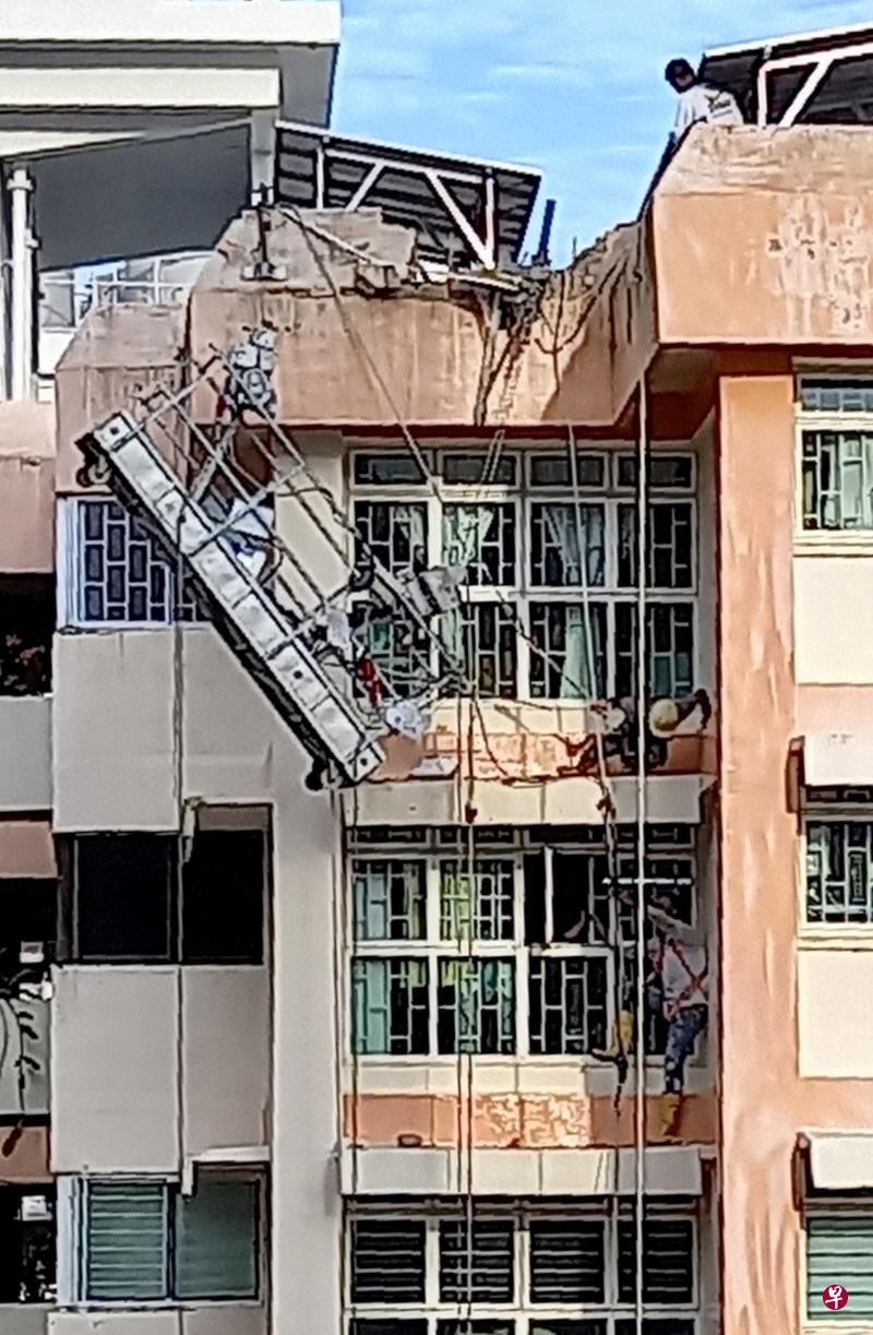两名客工分别困在14楼和15楼的墙沿处，受困14楼的工人很快获救，受困15楼的工人则在困了20分钟后脱险。（读者提供）