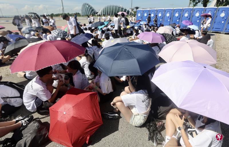 星期六烈日当空，全岛多个地点下午气温破36摄氏度，加上湿度高，在户外参加活动的人们纷纷撑伞或躲到阴凉处。（陈斌勤摄）