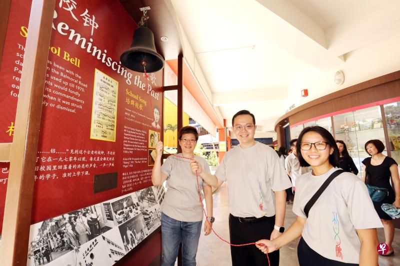公立培群学校在大巴窑培群校园举行建校90周年庆祝活动，校友黄佩纬（左起）、潘正祥、许凯婷在校钟前合影留念，他们分别毕业于上个世纪八十年代、九十年代与本世纪零零年代。（邝启聪摄）