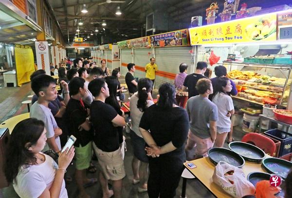 酿豆腐摊位亮起招牌后，出现40多名食客排队。（洪璐华摄）
