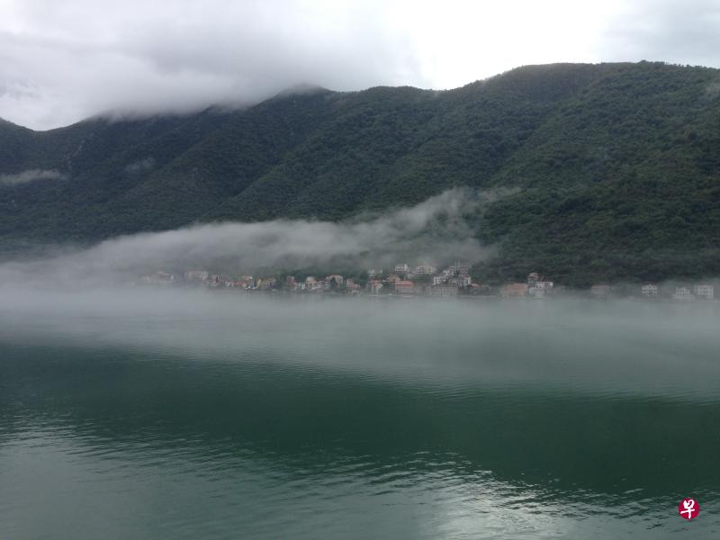 峡湾海面云水绵延上山。