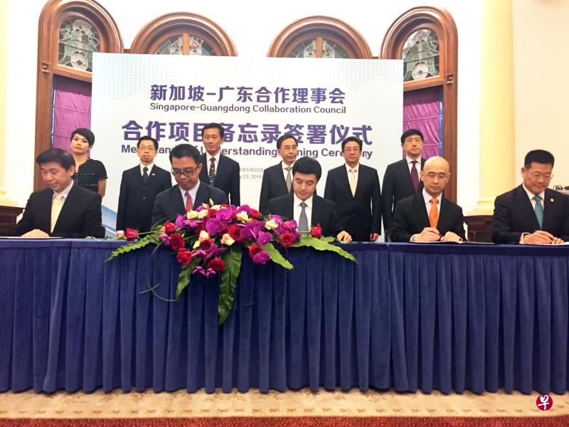在王乙康和朱小丹（后排左三、左四）的共同见证下，新粤昨日签署了三项合作协议。（曾实摄）