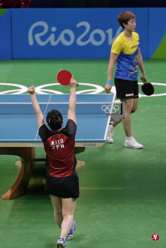 为日本拿下最后一分的15岁天才少女伊藤美城高举双手欢呼胜利，冯天薇黯然离场。（海峡时报）