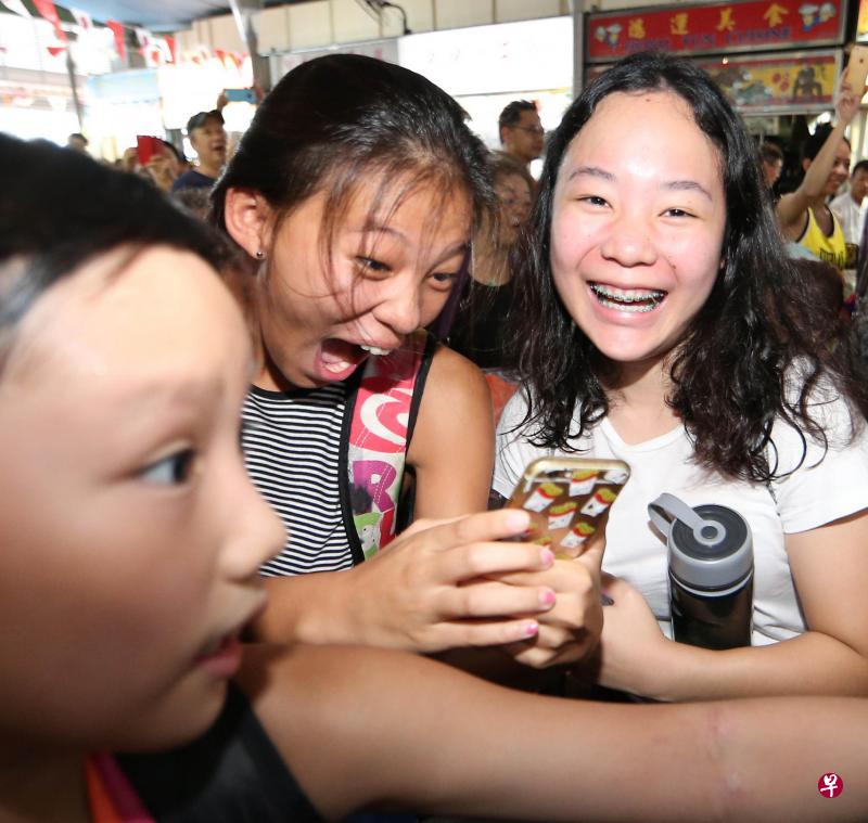 在汹涌人潮中还能捕捉到约瑟林的俊俏模样，令这名女粉丝和朋友兴奋不已。（何家俊摄）