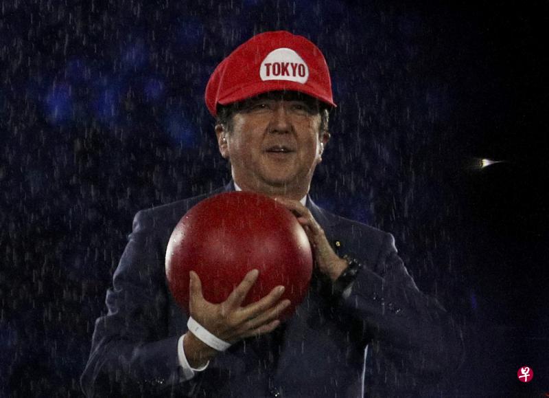 日本首相安倍晋三手中抱着的红球，象征着日本对体育的热爱。他在闭幕礼上化身为电玩人物超级马里奥（Super Mario）。（路透社）