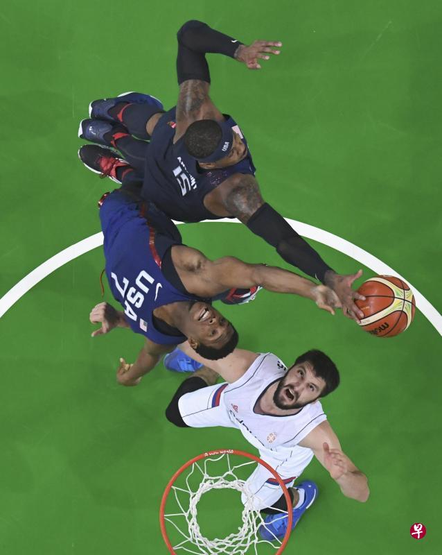 美国队的劳里（7号）与安东尼同塞尔维亚球员马科维奇抢夺篮板球。（路透社）