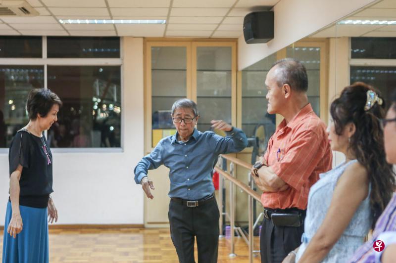 国标舞导师张德兴（蓝衣者）向学员传授舞步的秘诀。