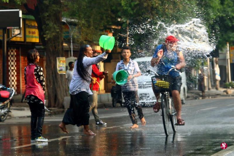 一名曼德勒居民热情地向路过的游客泼水。