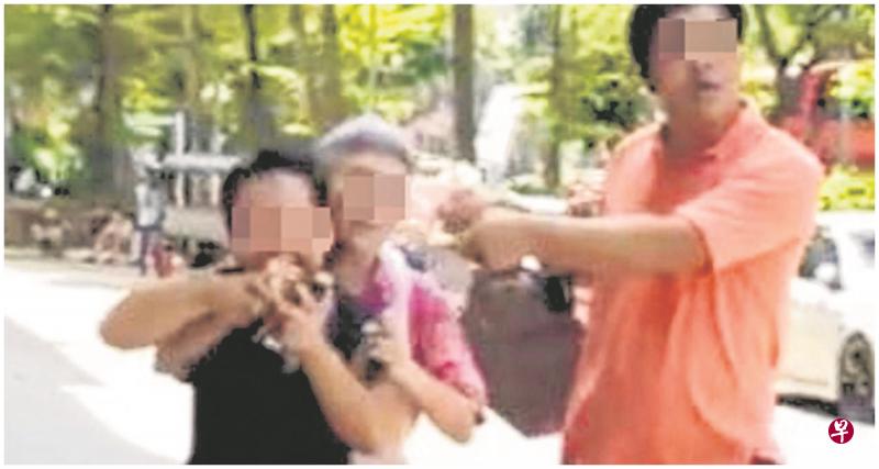 女摊主阻止女郎离开，女郎张嘴要咬女摊主。（受访者提供）