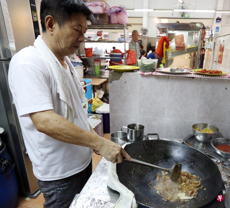 陈文杰不畏油烟，全神贯注炒着粿条。