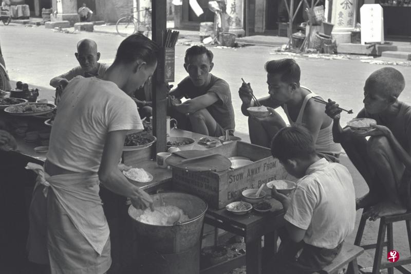 上世纪50年代街边小贩的菜色虽然简单，但顾客吃得津津有味。（档案照）