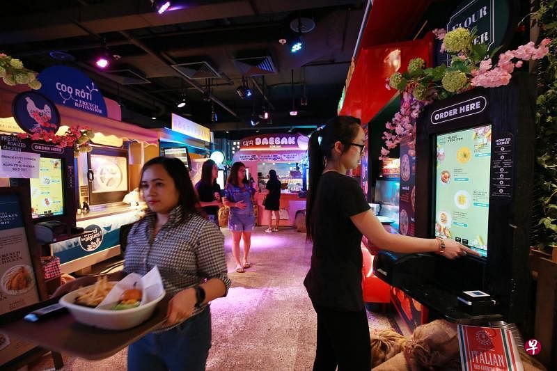 在位于威士马广场 （Wisma Atria）的Picnic餐馆，顾客使用电子点餐服务下单。（唐家鸿摄）