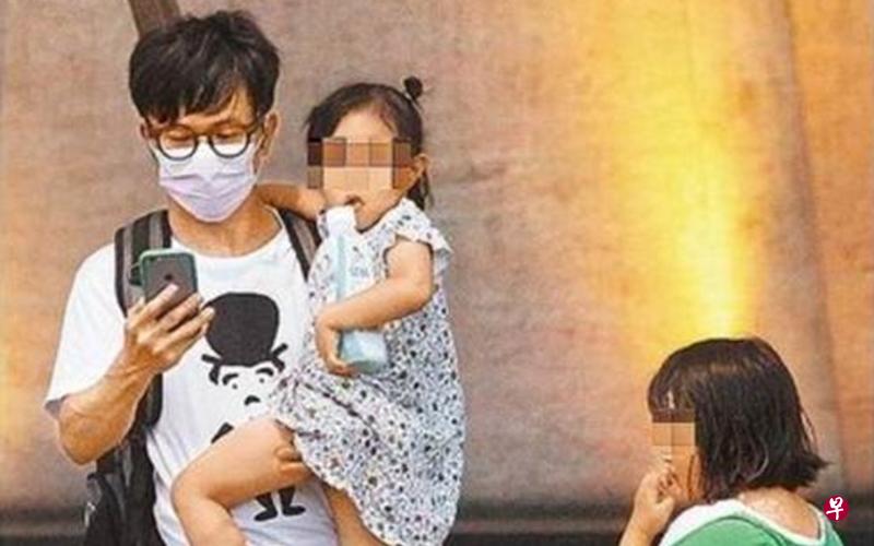 台湾苹果日报直击唐从圣带着两个小女孩在路边等车。
