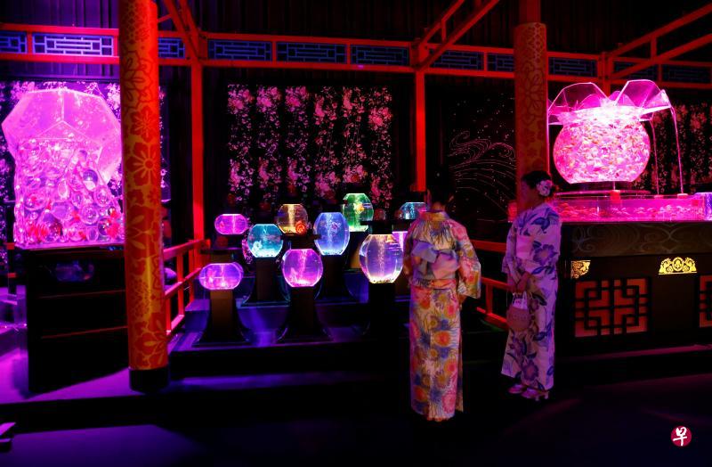 两名参观者正在东京桥三井会馆里观赏色彩缤纷的金鱼。（路透社）