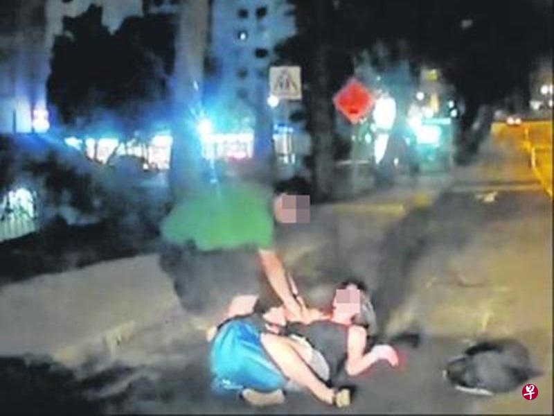 女子躺在马路上，男子试图把她拉起来。（互联网）