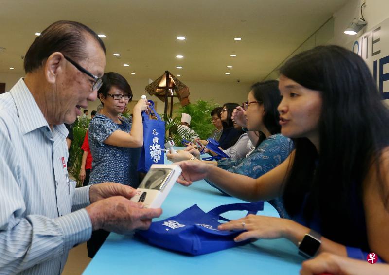 国庆群众大会的1300名出席者，昨晚在保健促进局的柜台领取免费计步器，开展日行万步的健康生活。（梁伟康摄）