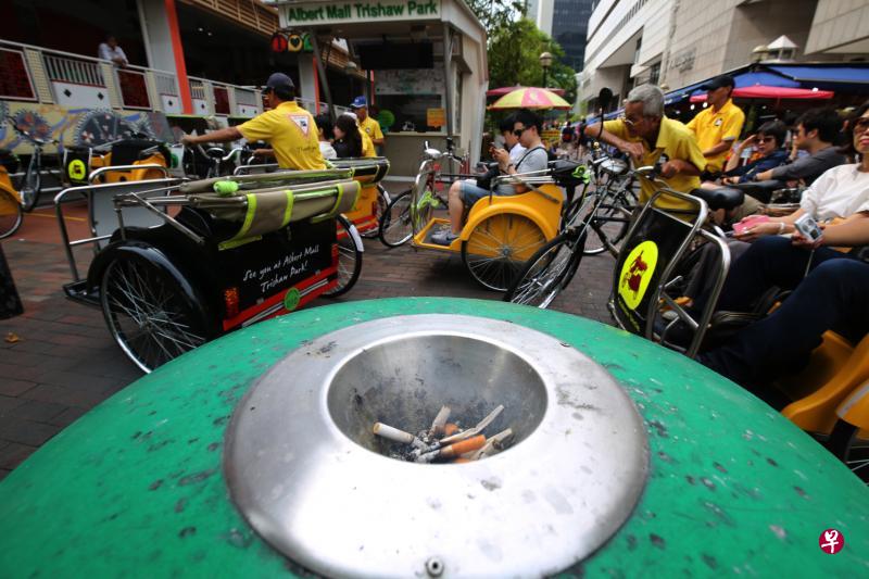 来自“三轮车大叔”（Trishaw Uncle）的车队，休息时全停靠在四马路观音堂和雅柏熟食中心旁的三轮车集中站。车夫要吸烟时就会聚集在不远处的垃圾桶周围，他们表示这么做虽然有点麻烦，但习惯了就好。也有车夫认为，坐在自己车上吸烟的行为“不好看”。（梁麒麟摄）