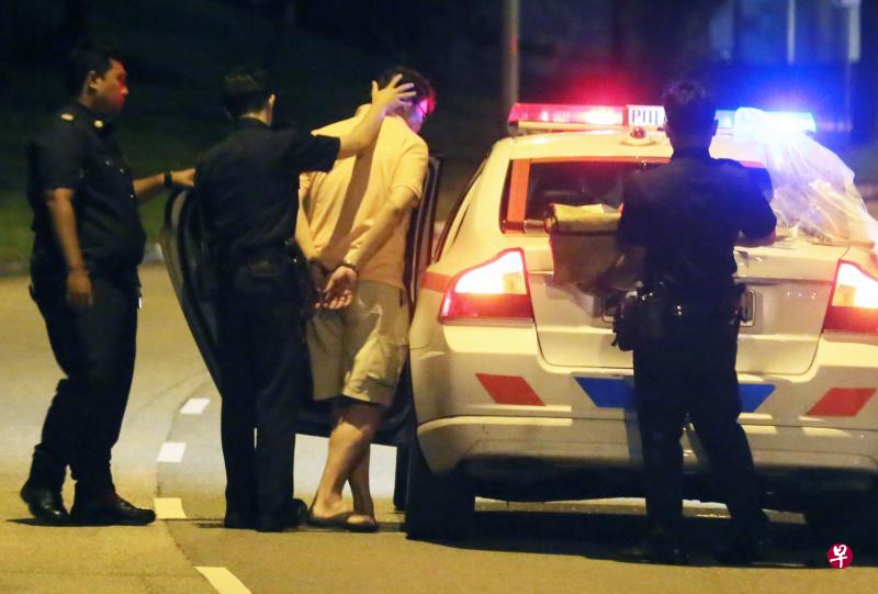 武吉巴督发生致命车祸，53岁肇祸男司机已在鲁莽行为导致他人死亡的罪名下被捕，由警员押上车。（新明日报）