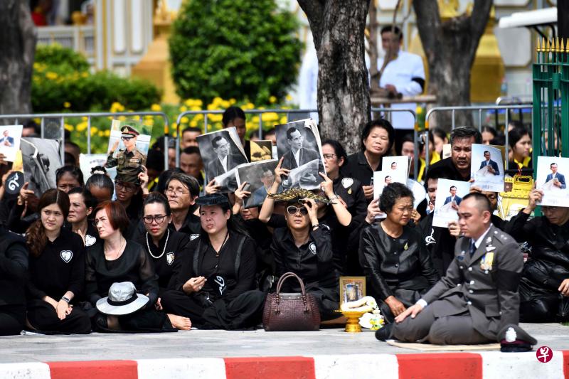 已故泰王蒲眉蓬今天（26日）移灵火化，泰国各地街头聚集不少哀悼的民众。（法新社）