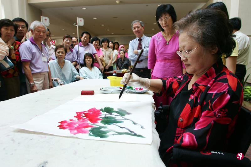 刚去世的本地女画家李淑芝当年因患上骨痛热症引起并发症，必须截去手肘以下的前臂和双脚，但她仍乐观面对，用义肢再执笔作画。（档案照片）