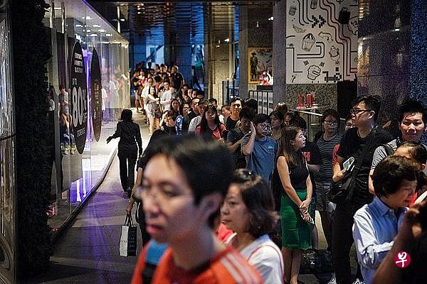 不少公众为购买特价商品漏夜排队，有公众今早拔腿奔入商场购物。（图／海峡时报）