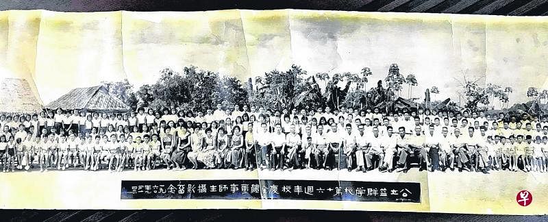 1960年益群学校全体校董及师生合影，照片左边背景为课室和戏台。（黎修兴提供）