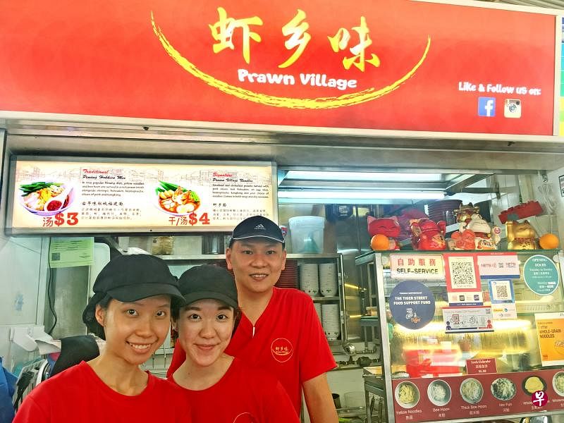 大学毕业生郉芷恩及陈庆怡在“虾乡味”老板卢文龙的虾面摊实习帮忙。 （苏慧珊摄）