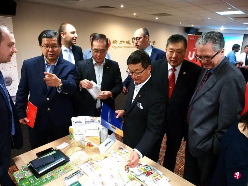 新加坡驻乌克兰大使西蒙德克鲁斯（Simon Tensing De Cruz，前排右起）、食品厂商联合会会长白毅柏、中华总商会会长黄山忠、总商会董事陈睦发和食品厂商联合会副会长陈来福向乌克兰商家了解当地产品。（中华总商会提供）