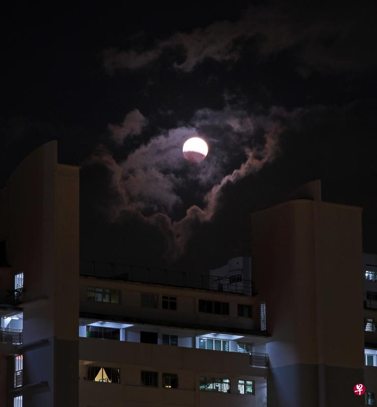 大雨后天空放晴，“超级蓝月”终于从云雾中露出身影，让满心期待的国人雀跃万分。（林泽锐摄）